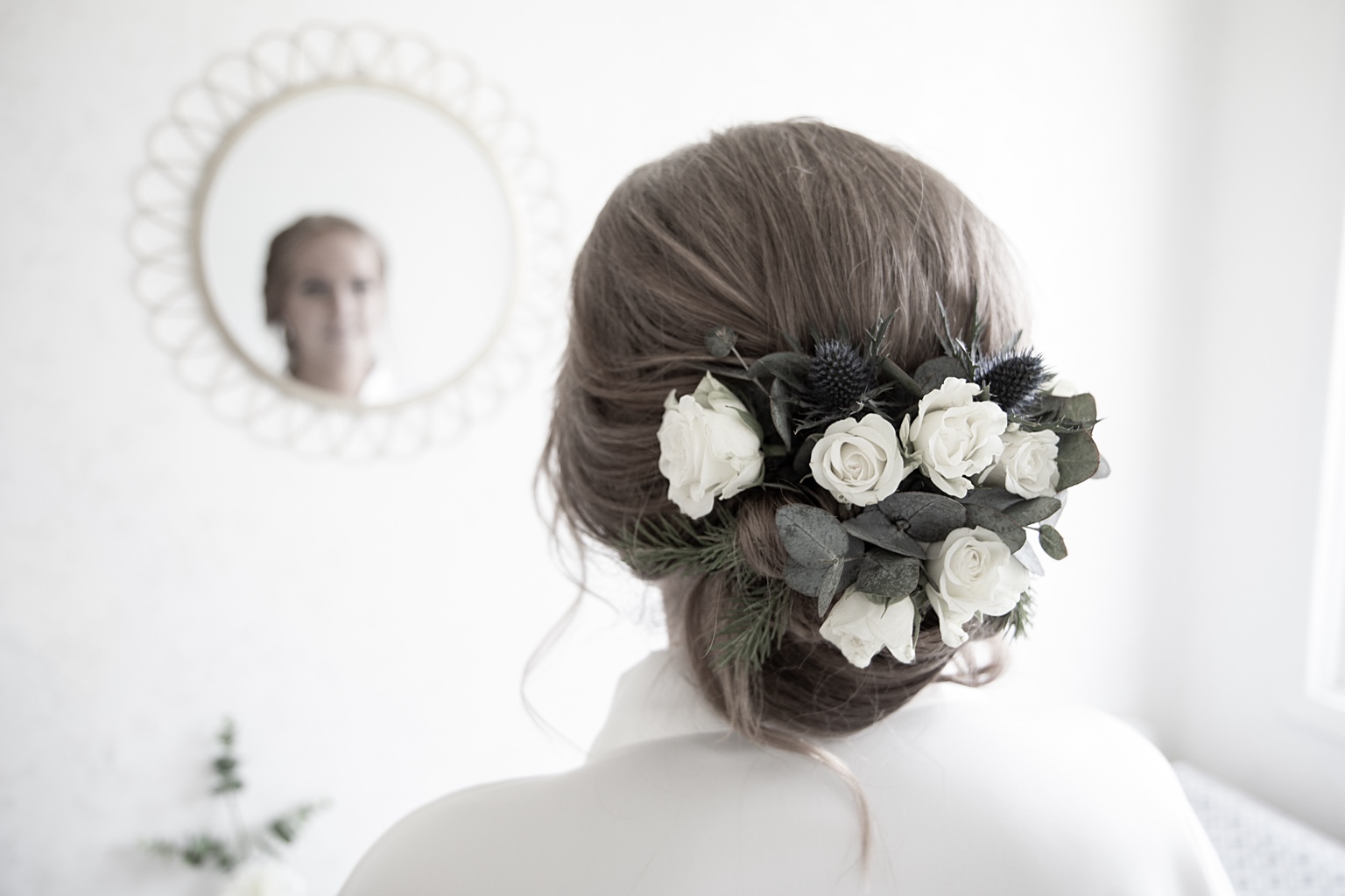 Blommor i brudens hår och hennes spegelbild